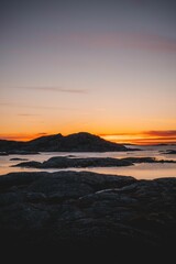 Scenic view of rocky islands surrounded by the tranquil waters of the ocean at sunset.
