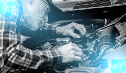 Car mechanic working on car engine; light effect