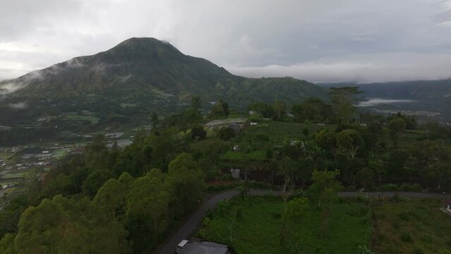 Aerial view of Batur volcano, farmland, lake, sunrise, clouds, Pinggan, Kintamani, Bali, Indonesia.