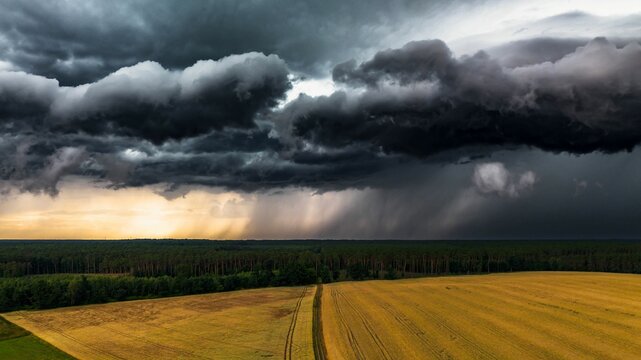 Dramatic view of an incoming storm over a vast expanse of plains, with dark clouds rolling
