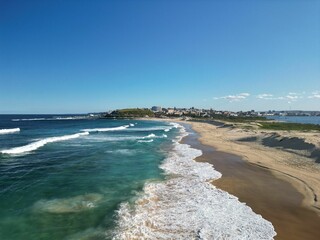 Aerial view captures a tranquil beach scene with the calming sight of gentle waves