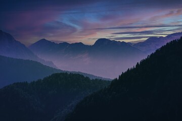 Fototapeta premium Vibrant sky at sunset over majestic mountains.