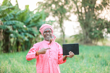 Indian farm worker holding tablet