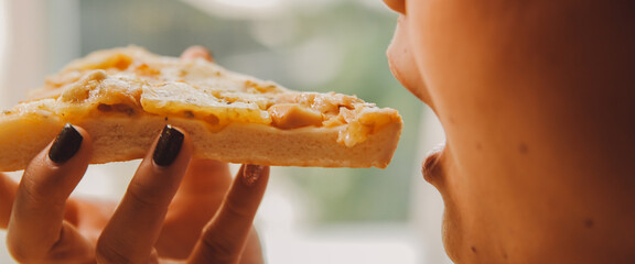 Cropped image of woman holding pizza slice at restaurant