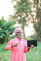 Indian farm worker holding tablet