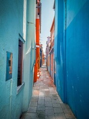 Fototapeta premium Vertical of a narrow street between colorful houses on Burano, Italy