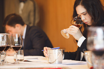 Female Wine Enthusiast Engaged in Smelling Analysis at Wine Tasting Exam. 