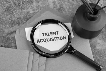 Talent acquisition concept. Process employers use for recruiting. Text TALENT ACQUISITION written through a magnifying glass on a piece of paper sticking out of an envelope. Classified information