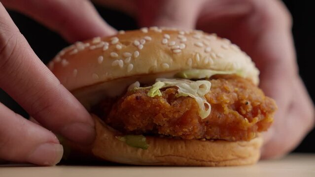 Person Lay Down A Crunchy Fried Chicken Burger On The Table. Rack Focus Shot
