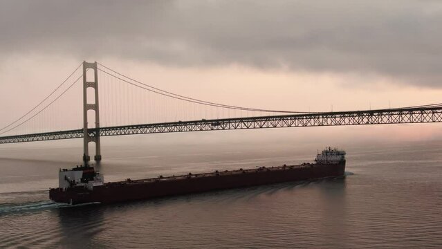MV Paul R. Tregurtha vessel passing under Mackinac Bridge at sunset