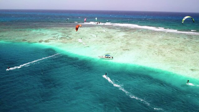 Kitesurfers on vibrant turquoise waters at boca del medio, los roques, aerial view