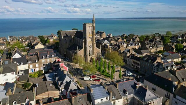 Saint-Meen church with sea in background, Cancale, Brittany in France. Aerial drone orbiting