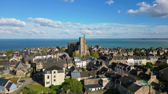 Saint-Meen church with sea in background, Cancale, Brittany in France. Aerial drone forward ascending