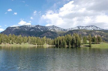 Idyllic lake situated in a mountainous region with lightly clouded skies above