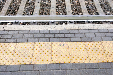 Train Station Platform with Yellow Tactile Paving and Rail Tracks - Travel and Transport Concept