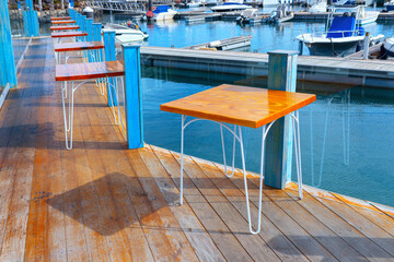 Scenic wooden deck featuring tables and chairs. Ideal place for enjoying meals outdoors. Restaurant...
