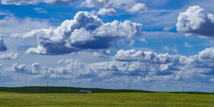 Scenic view of rolling green hills dotted with white clouds