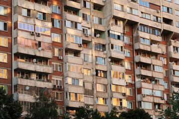 The many windows of a concrete, socialist, brutalist panel, multi-story, high-rise, apartment...