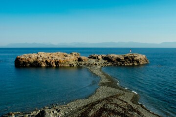 a couple of rock formations near the shore of a bay