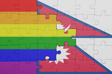 puzzle with the colourful national flag of nepal and rainbow gay pride flag .