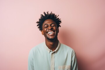 Fototapeta premium Portrait of a glad afro-american man in his 20s laughing isolated in solid pastel color wall