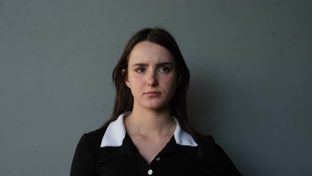 portrait of a young brunette woman showing the emotion of dissatisfaction
