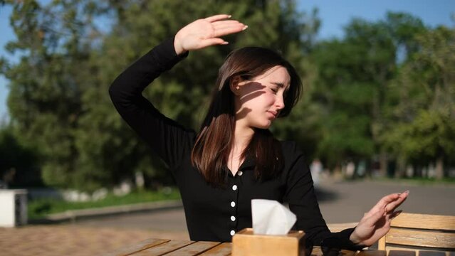 woman squints from the bright sun and puts on sunglasses