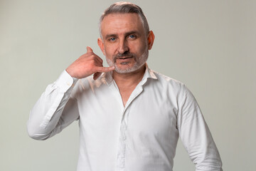Man in white dress shirt with beard making call me gesture