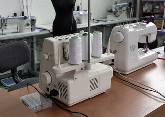 Professional sewing machines in a sewing workshop, with threads, for sewing clothes, close-up.