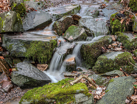 the stream is flowing over many rocks covered in mossie