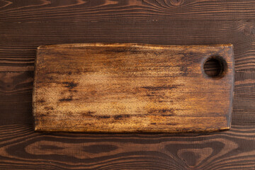 Empty rectangular wooden cutting board on brown wooden. Top view