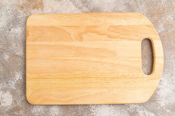 Empty rectangular wooden cutting board on brown concrete. Top view