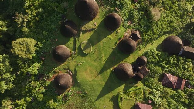 Aerial view of traditional village with thatched roof huts and lush forest, wae rebo, flores, indonesia.