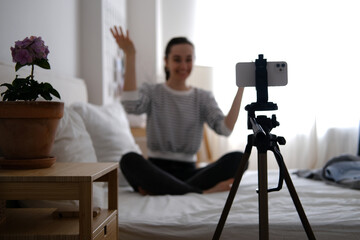 Young beautiful woman blogger making a video for her blog using phone camera at home.