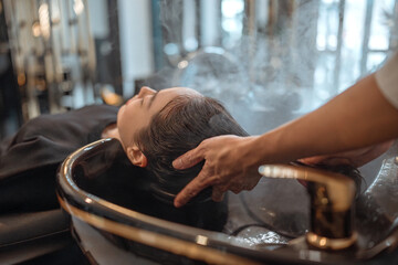 Hairdresser in beauty salon massage head customer and hair care in procedure of steaming water steam. Customer feeling relax while hairdresser massaging head at beauty barber shop
