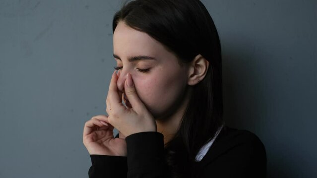 portrait of a woman covering her nose from a bad smell