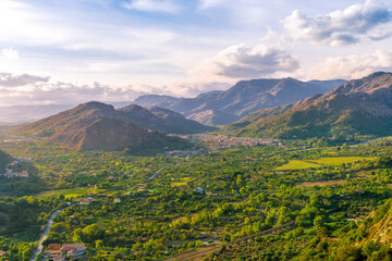 Obraz premium amazing highland view from above to a canyon and valley between mountains and green hills, cloudy sunset landscape of beautiful highland