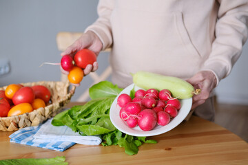 Plate with fresh vegetables in woman's hands