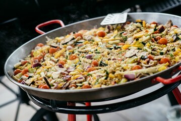 Sizzling pan of rice and colorful vegetables being cooked