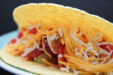Delicious taco with cheese, tomato, onions, and peppers
