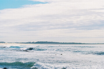 some people are out in the ocean with surf boards and the ocean is calm
