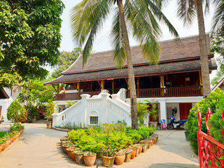 A classical architecture and vibrant greenery on a sunny day in Luang Prabang