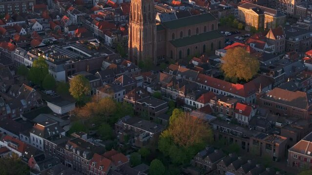 Aerial view of city with historic cathedral, rooftops, and river Waal at sunset, Gorinchem, Netherlands.