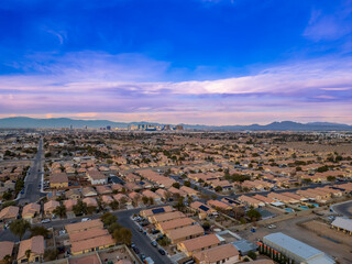 Twilight view of Las Vegas neighborhood with uniform homes, leading to the iconic Strip © Wirestock