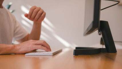 Hands of an office man typing on computer keyboard, Freelance working remote concept, Hands typing on computer keyboard in office desk or living room area at home.