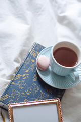 White teacup with a macaron resting on vintage book