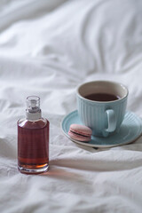 Coffee cup and syrup bottle on bed