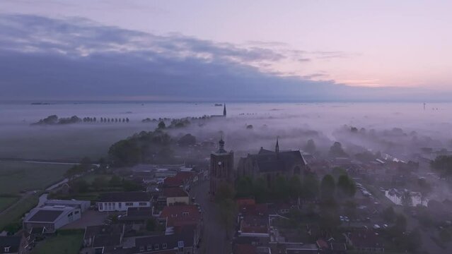 Aerial view of foggy cityscape with church and rooftops, Workum, Friesland, Netherlands.