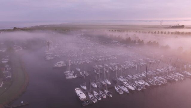 Aerial view of boats in foggy harbour at sunrise, Workum, Friesland, Netherlands.