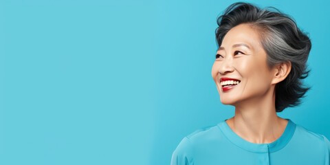 Blue Background Happy Asian Woman Portrait of Beautiful Older Mid Aged Mature Smiling Woman good mood Isolated Anti-aging Skin Care Face Beauty Product Banner 